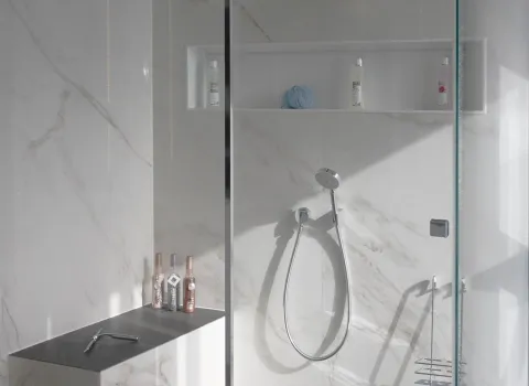 Badezimmer mit grauen Marmorfliessen und Armaturen von VOLA