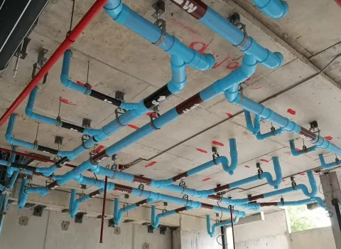 Viele blaue Wasserrohre, die an der Decke miteinander verbunden sind.