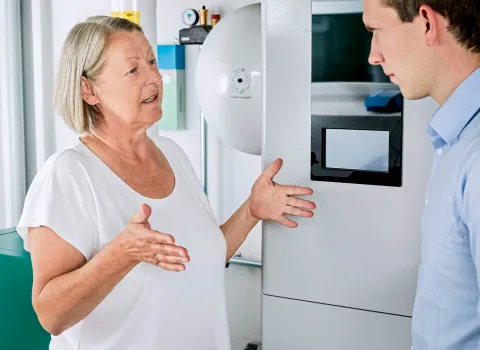 Ein Kundengespräch zur Energieberatung vor einer Heizungsanlage.