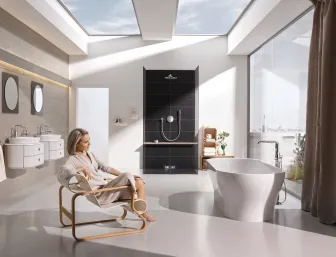 Sitzende Frau im Komplettbad mit High-End-Ausstattung von GROHE..