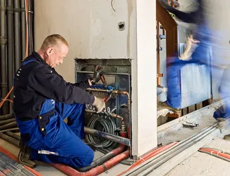 Anlagenmechaniker SHK bei der Verlegung einer Fußbodenheizung.